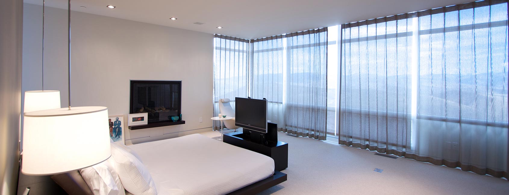 Modern Park City bedroom featuring automated motorized window shades, recessed LED lighting, and smart lighting controls for energy-efficient ambiance and comfort