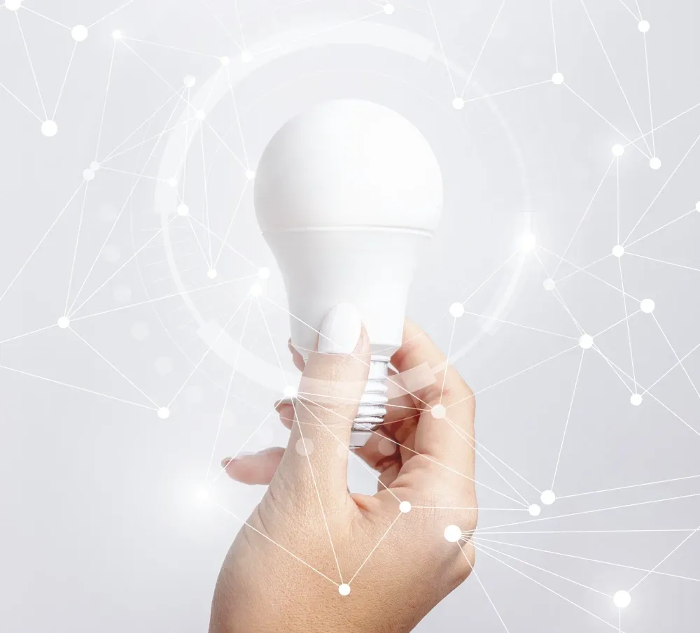 Hand holding smart LED bulb illustrating Deer Valley lighting control systems for enhanced ambiance, energy efficiency, and personalized home automation